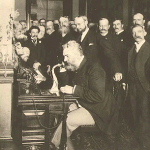Alexander Graham Bell speaks into telephone