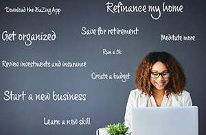 Woman seated at computer with Goals on chalkboard behind her